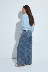 Jean de corte wide leg con estampado de cuadros en tonos azules. Presenta un diseño de tiro medio y silueta amplia, confeccionado en denim estructurado.