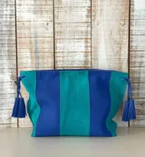Sobre de cuero gamuzado con diseño bicolor en tonos azul y verde, con borlas decorativas en los laterales.