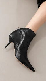 Bota corta de cuero con acabado metalizado plateado, punta fina y taco aguja de 8 cm.