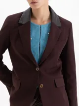 Blazer sastrero color chocolate confeccionado en twill, con solapas de cuero vacuno, bolsillos con tapa y cierre frontal de dos botones.