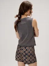 Short holgado de cintura alta con pretina integrada, cordón ajustable delantero y estampado geométrico en tonos rojos y beige.
