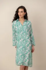 Vestido midi verde con estampado de arabescos, cuello camisero con escote en V y cierre frontal parcial de botones, de manga corta y corte recto.