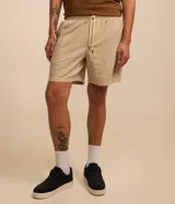 Bermuda masculina color beige claro, con textura, cintura elástica ajustable con cordón y bolsillos laterales.
