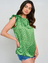 Blusa sin mangas color verde con estampado abstracto en blanco, cuello redondo fruncido y volados en los hombros.