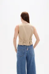 Chaleco sastrero de algodón, con escote en V, cierre frontal con botones y diseño entallado.