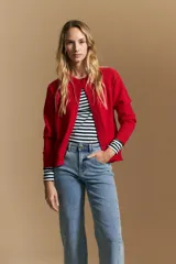 Cardigan de tejido de punto color rojo, con cuello redondo, cierre frontal de botones al tono y puños acanalados.
