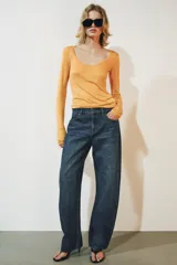 Jeans de tiro medio confeccionados en denim con efecto lavado, diseño de pernera curva y corte recto. Cuenta con cinco bolsillos, trabillas en la cintura y cierre frontal con cremallera y botón metálico.