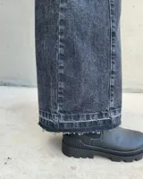 Pantalón de jean estilo wide leg con costuras verticales frontales, tiro alto y bolsillos laterales.