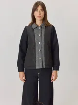 Campera de diseño híbrido con frente acolchado en rombos, solapa central y cuello en lana gris con patrón de espiga, y mangas de lana negra. Presenta cierre frontal con botones y forro interior de lana.