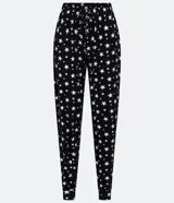 Pantalón de pijama negro con estampado de estrellas blancas, cintura elastizada con cordón ajustable y tobillos ajustados.