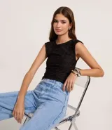 Blusa sin mangas de color negro, confeccionada en tejido texturizado con cuello redondo y abertura en la espalda.