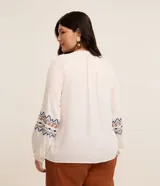 Blusa bata femenina de viscosa color blanco, con cuello redondo con lazo y borlas, manga larga con ajuste en el puño y estampa étnica en los puños.