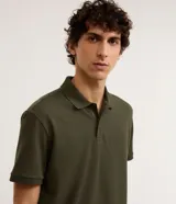 Remera polo de manga corta color verde militar, confeccionada en algodón peruano con cuello convencional y cierre de botones.