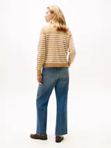 Sweater de punto fino en algodón peinado, con diseño a rayas horizontales en color beige y blanco. Presenta cuello redondo, puños y bajo en punto canalé, y detalle de botones dorados decorativos en uno de los hombros.