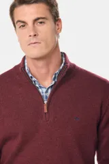 Buzo tejido de lana con cuello alto y medio cierre metálico frontal. Presenta puños y ruedo acanalados, con logo bordado en el pecho.