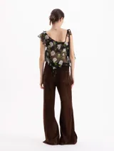 Pantalon de tiro alto y silueta wide leg confeccionado en cuero caprino con acabado de gamuza color chocolate. Presenta recortes verticales que estructuran la prenda y tajos laterales en el ruedo.