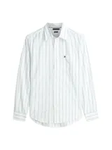 Camisa de manga larga de Tommy Hilfiger, color blanco con finas rayas verticales celestes, corte amplio, cuello clásico, cierre frontal con botones, un bolsillo de parche en el pecho con el logo bordado y puños abotonados.