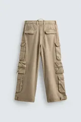 Pantalón cargo de denim lavado negro, corte relajado y tiro medio. Presenta múltiples bolsillos cargo con solapa y detalle de cierre en las perneras, además de bolsillos de vivo traseros. El bajo es ajustable con trabilla.