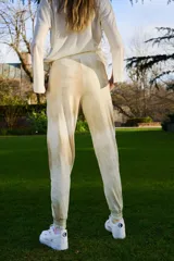 Pantalón de jogging color beige con efecto batik, confeccionado en tejido rústico. Presenta bolsillos diagonales laterales, cintura y botamanga con puño, y detalle bordado de la marca en el bolsillo.