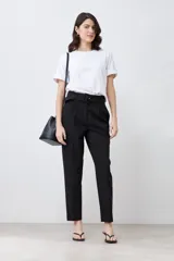 Remera blanca de manga corta con cuello redondo y botón metálico en los puños.