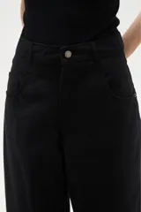 Pantalon de jean estilo barrel, color natural, de tiro medio con bolsillos laterales y cierre frontal.