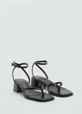 Sandalia negra con cierre de tira con hebilla, diseño de tiras finas y punta cuadrada. El tacón mide 4,5 cm.