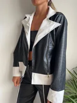 Campera de cuero sintético negra con textura de cocodrilo, con cuello, solapas y puños en color blanco.