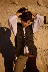 Chaleco de tweed con diseño estructurado y volados decorativos en lino. Presenta un cierre frontal con cintas para atar y un corte entallado.