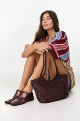 Sandalias Mary Jane de cuero color bordeaux, con diseño de tiras cruzadas, puntera cuadrada y taco bajo.