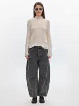 Polera color crema de tejido suave con cuello alto y mangas largas.