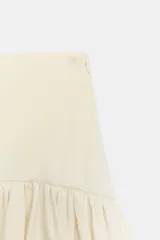 Falda de tiro medio color amarillo claro, confeccionada en tejido de punto elástico con detalle de aplicación combinada y bajo en línea evasé. Cuenta con cierre lateral con cremallera oculta.
