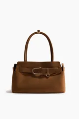 Bolso tote de acabado suave, color marrón, con asas tubulares unidas por una trabilla con hebilla metálica. Presenta una correa decorativa frontal con hebilla metálica y compartimento interior con cierre.