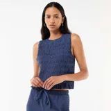 Top azul sin mangas de corte recto, con textura fruncida en todo su diseño, cuello redondo con sutil volado y terminación ondulada en el ruedo.