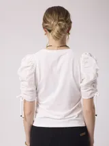 Remera blanca de algodón con mangas abullonadas de plumeti y lazos ajustables en los puños.