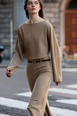 Top crop color beige, de cuello barco y manga larga, con bajo redondeado.