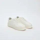 Zapatillas urbanas de plataforma color blanco, con diseño minimalista, cordones al tono y suela de goma reforzada.