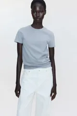 Remera entallada de punto de algodón elástico, color gris, con cuello redondo fino ribeteado y bajo recto.