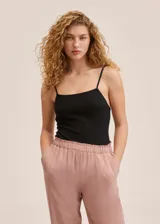 Pantalón de corte fluido y tiro alto, con cintura elástica y detalle de volado en la parte superior. Cuenta con bolsillos laterales.