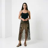 Falda midi de tul negro con diseño geométrico y arabescos bordados en hilo negro y lentejuelas. Presenta una silueta recta con transparencia y forro corto integrado.