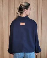 Chaqueta de textura bouclé en color bordó, con corte oversize, cuello camisero, cierre frontal y bolsillos laterales.