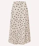 Pollera midi de corte evasé, confeccionada en tricolina de algodón con estampado de lunares negros sobre fondo blanco. Presenta una silueta estructurada, cintura lisa en la parte delantera y elástico en la espalda.