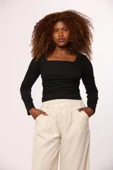 Blusa de manga larga color negro, con escote cuadrado y diseño ajustado con frunces laterales.