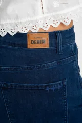 Jean de corte baggy con tiro medio, confeccionado en denim de algodón. Presenta un diseño de pierna ancha con estructura curva tipo barril y cierre frontal con botón y cremallera.