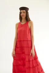 Vestido largo de lino color amarillo mostaza, sin mangas con diseño de espalda nadadora y escote a la base, con detalles de mini volados horizontales escalonados a lo largo de la falda.