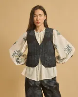 Chaleco corto azul con escote en V y cierre de gancho. Diseño acolchado.