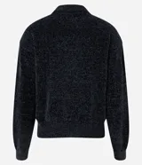 Suéter de chenille color negro con textura suave, cuello alto y puños con ribana. Presenta un diseño de corte clásico con mangas largas y terminación acanalada en el bajo.