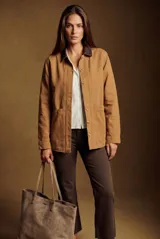 Sobrecamisa de algodón en color camel, con cuello camisero en contraste de tono oscuro, cierre frontal de botones y bolsillos laterales aplicados.