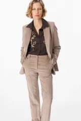 Blazer de corte clásico confeccionado en tela aterciopelada color bordó, con cuello solapa, cierre frontal con botones y bolsillos laterales tipo ojal.