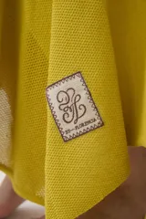 Falda larga de punto color mostaza, con cortes asimétricos, distintos puntos texturizados, ruedo irregular y pretina elástica con detalles en tono contrastante.
