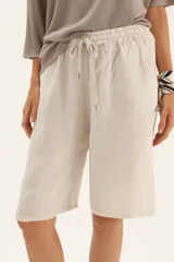 Bermuda larga color beige confeccionada en lino, con cordón ajustable en la cintura.